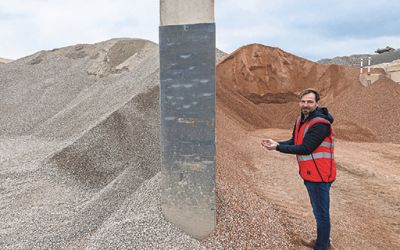 Michael Hallwachs vor recycelten Zusatzstoffen für Beton: links aus Betonschutt, rechts aus Ziegelschutt.